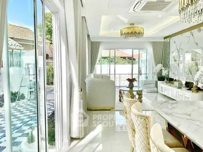 Luxurious living room with elegant decor and large windows opening to a stylish outdoor area.