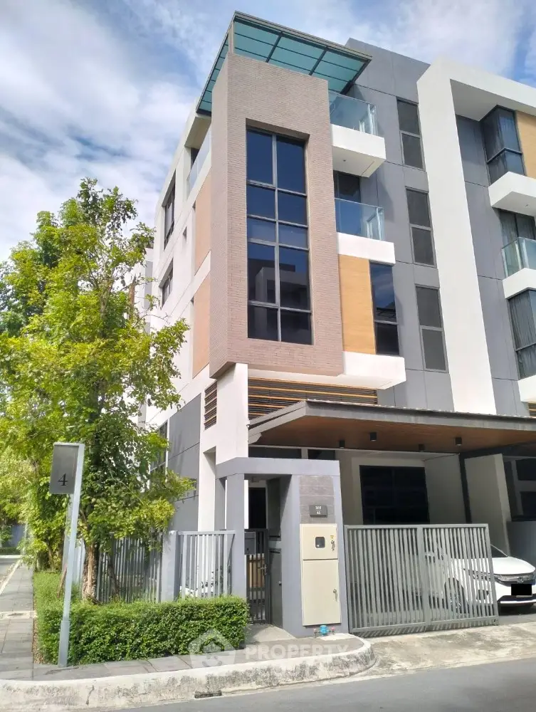 Modern multi-story residential building with sleek design and large windows