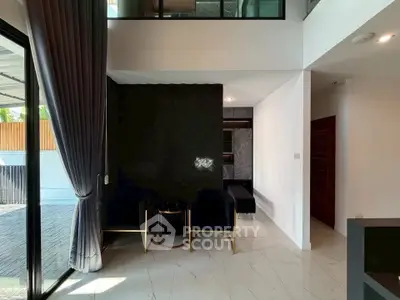 Modern living room with elegant decor and large windows offering natural light