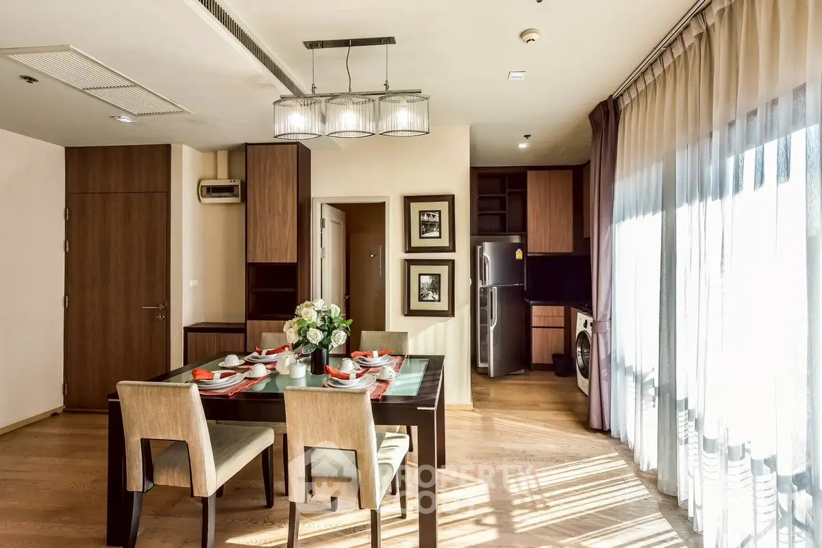 Elegant dining area with natural light and modern kitchen in luxury apartment