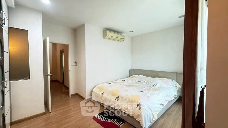 Spacious bedroom with modern air conditioning and cozy decor in a well-lit apartment.