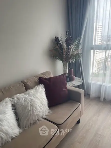 Cozy living room with plush sofa and city view through large window