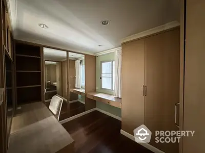 Spacious walk-in closet with wooden cabinetry and natural light