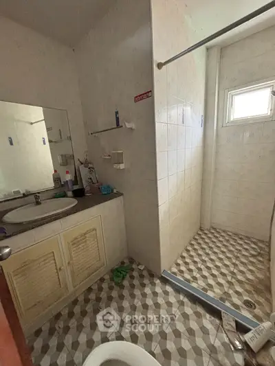 Cozy bathroom with shower and vintage tile flooring in a charming home.
