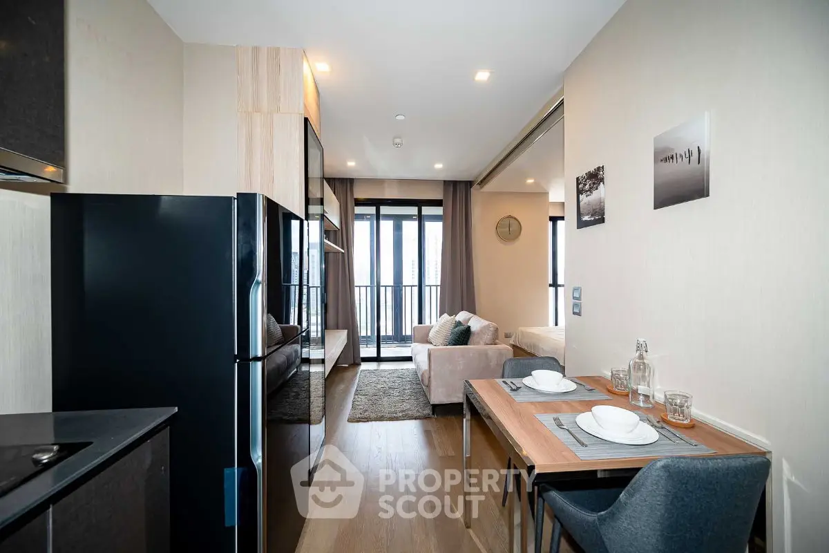 Modern open-plan living room with dining area and balcony view in a stylish apartment.