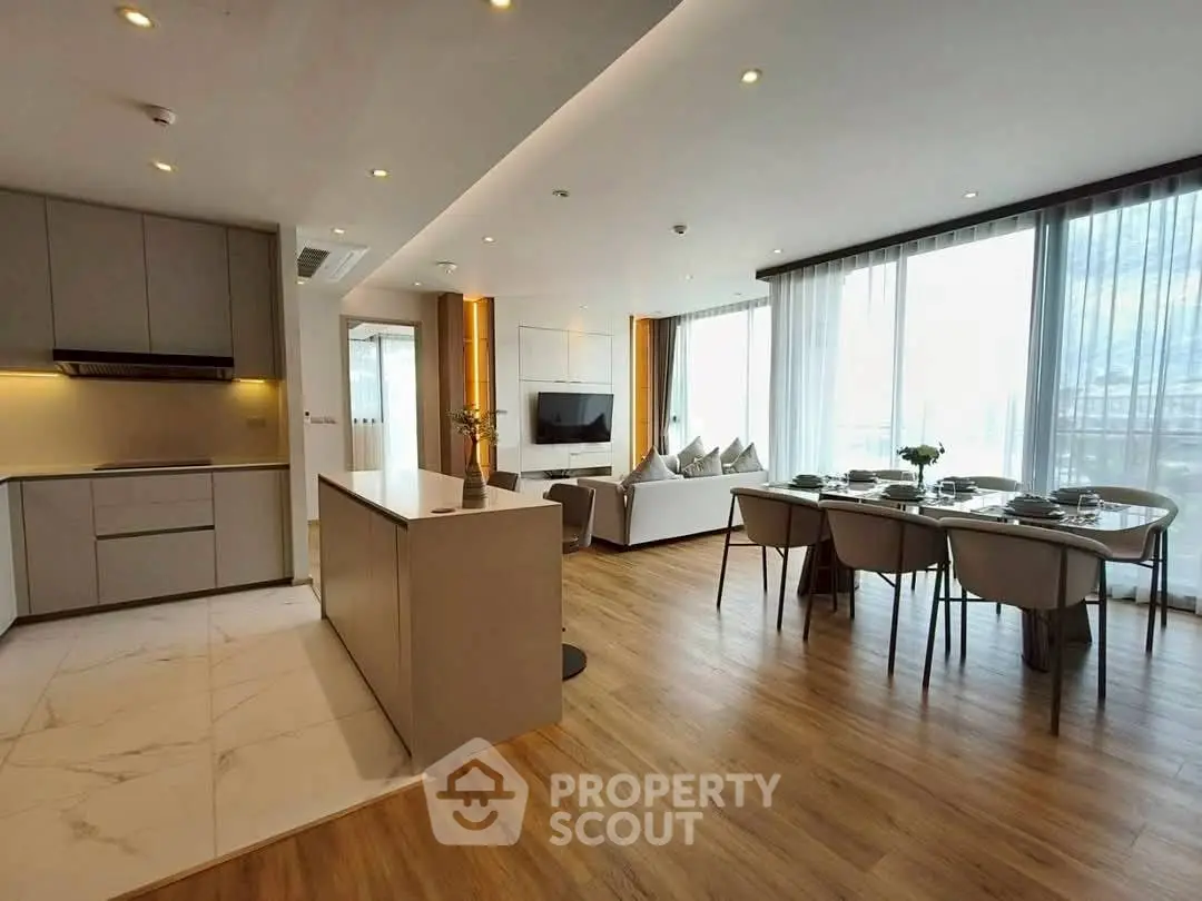 Spacious open-plan living and dining area with modern kitchen and elegant decor.