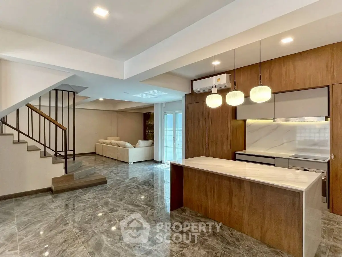 Spacious modern living room with open kitchen and elegant staircase