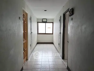 Bright hallway with tiled floor and wooden doors in residential building