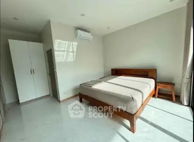 Spacious bedroom with modern furnishings and natural light