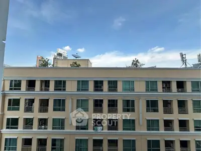 Stunning view of a modern apartment building with clear blue skies, perfect for urban living.