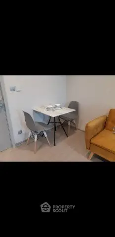 Modern dining area with stylish chairs and cozy sofa in a contemporary apartment.