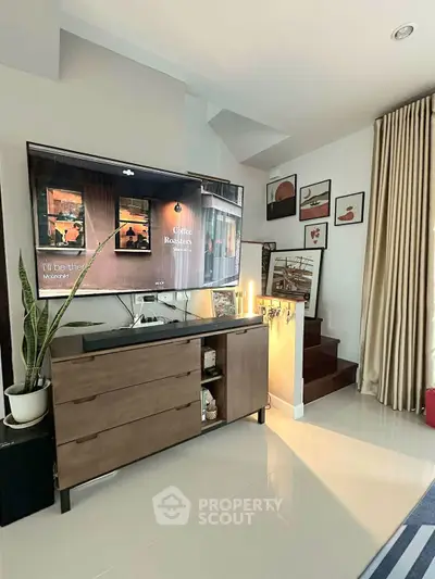 Modern living room with stylish decor and large TV, perfect for relaxation.