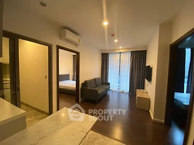 Modern apartment interior with open layout, featuring a cozy living room and adjacent bedroom.