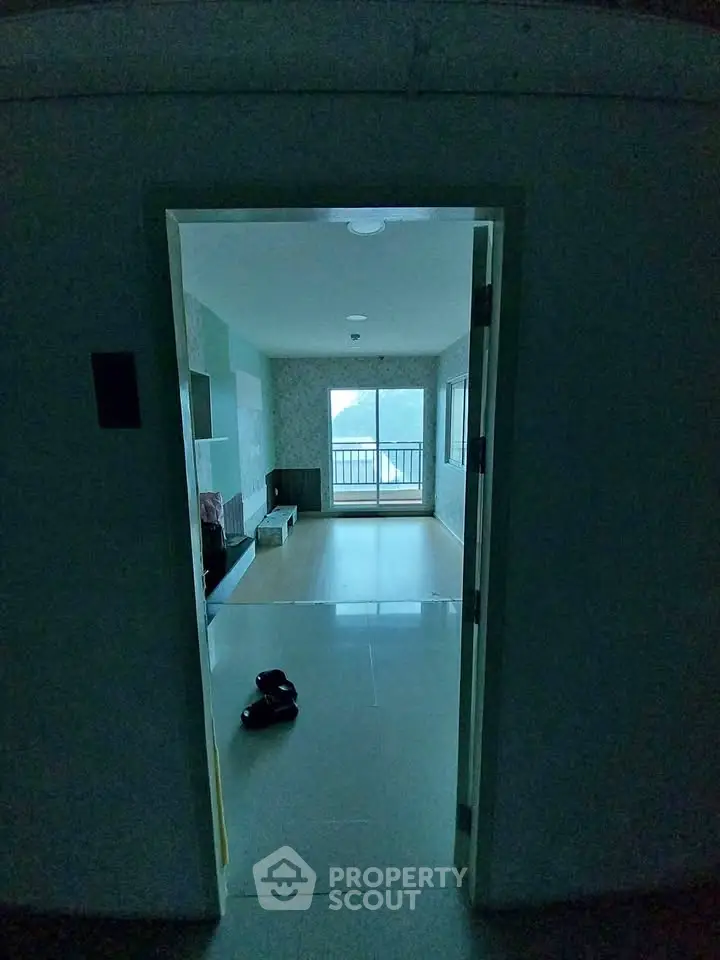 Spacious living room with large windows and balcony access, offering abundant natural light and scenic views.