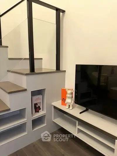 Modern living room with sleek TV stand and staircase