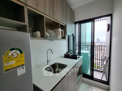 Modern kitchen with sleek cabinetry and balcony view in urban apartment