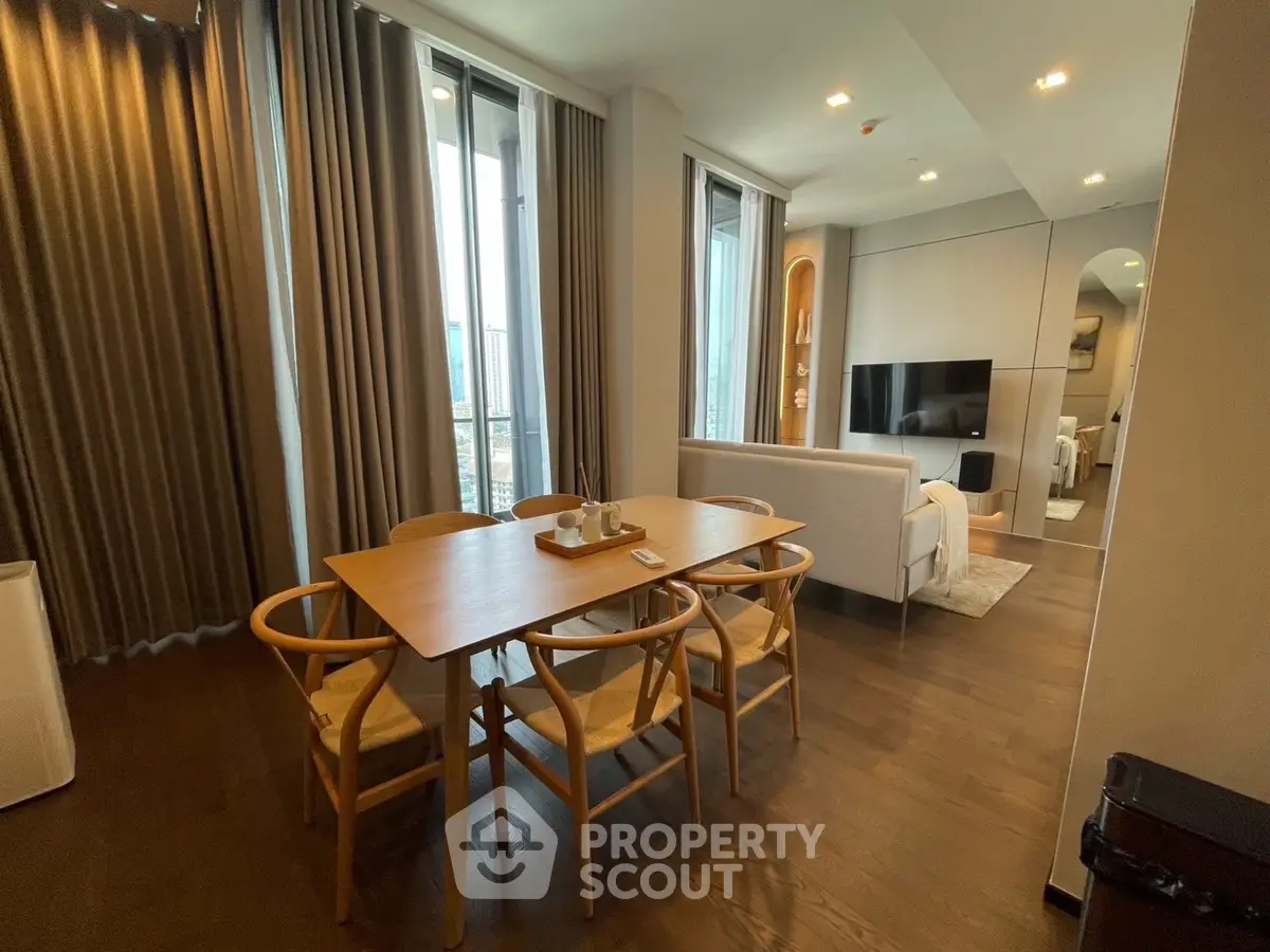 Modern open-plan living and dining area with stylish furniture and floor-to-ceiling windows.