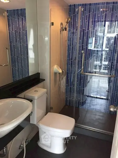 Modern bathroom with sleek shower and stylish blue tile accents