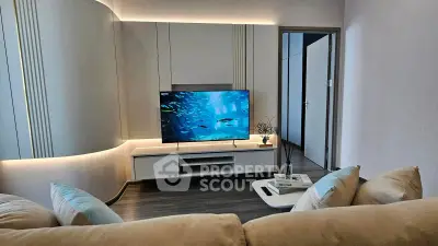 Modern living room with sleek TV setup and cozy seating, perfect for relaxation and entertainment.