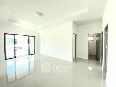 Spacious modern living room with large windows and glossy tiled floors