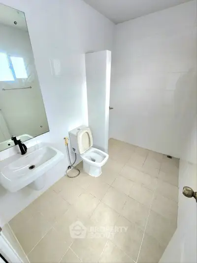 Spacious minimalist bathroom with modern fixtures and natural light