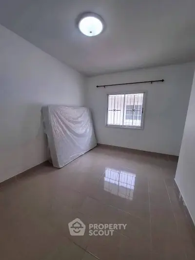 Spacious unfurnished room with tiled flooring and natural light, ideal for customization.
