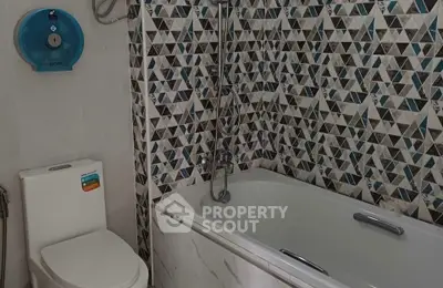 Modern bathroom with geometric tile design and bathtub