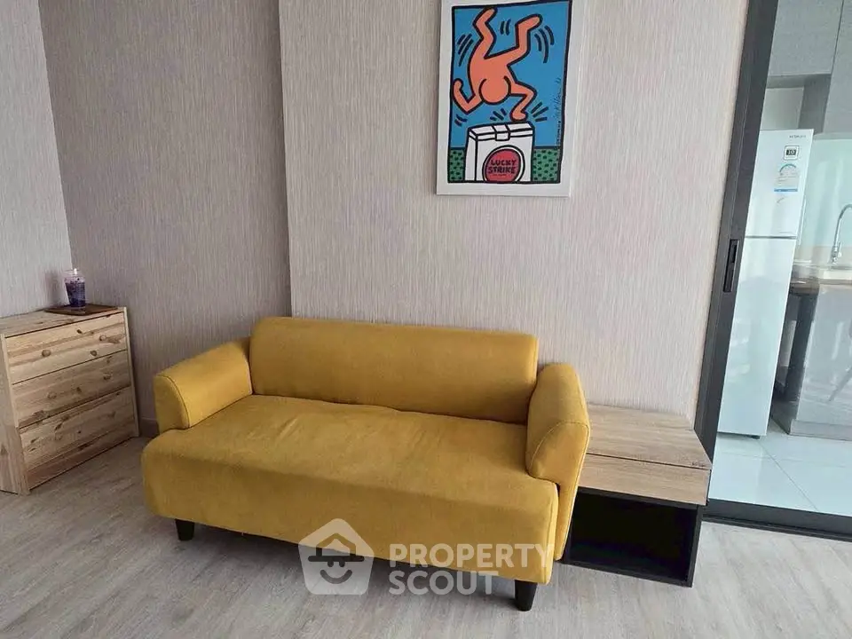 Modern living room with vibrant yellow sofa and stylish artwork, perfect for contemporary urban living.