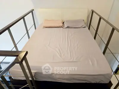 Cozy bedroom with modern railing and neatly made bed, perfect for urban living.