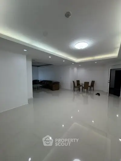 Spacious modern living room with elegant ceiling lights and dining area.