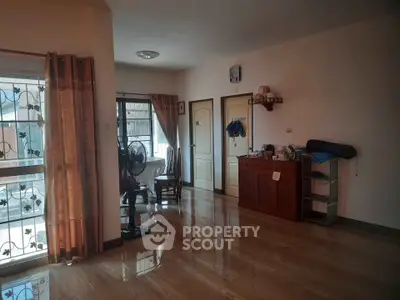 Spacious living room with polished wooden floors and natural light