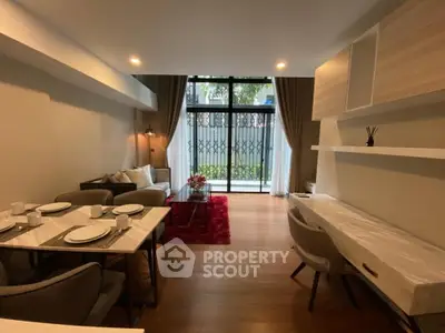 Modern living room with elegant dining area and large windows opening to a garden view.