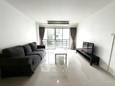 Spacious modern living room with sleek furniture and large windows offering natural light.