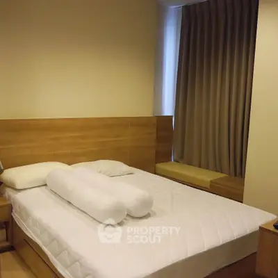 Cozy bedroom with modern wooden furniture and soft lighting, perfect for relaxation.