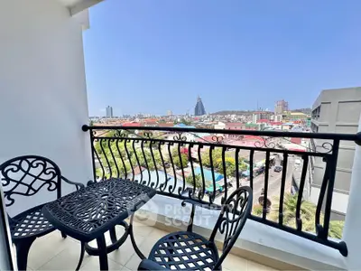 Charming balcony with cityscape view, featuring elegant wrought iron furniture, perfect for relaxation.
