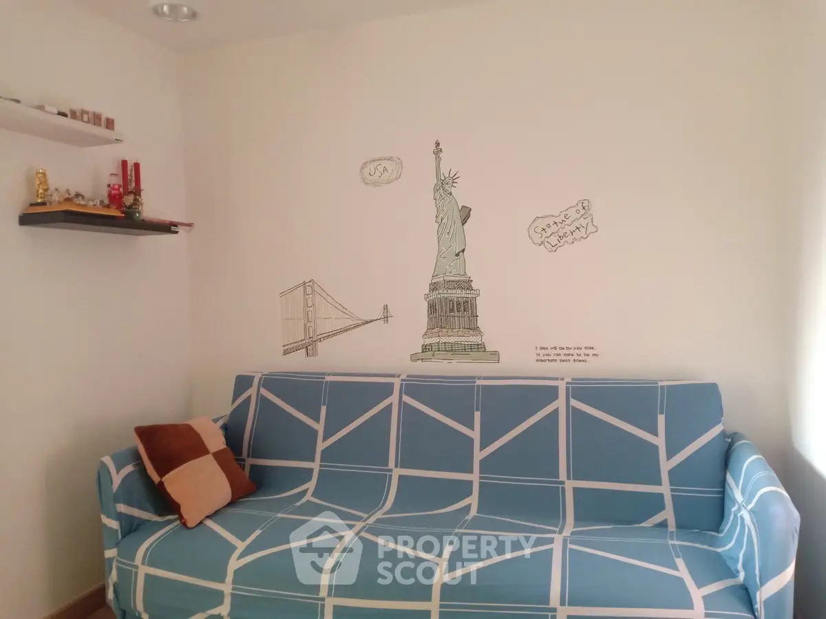 Cozy living room with stylish sofa and wall art featuring iconic landmarks.