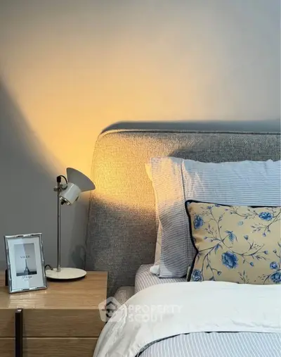 Cozy bedroom with stylish decor, featuring a modern lamp and elegant bedding for a serene ambiance.