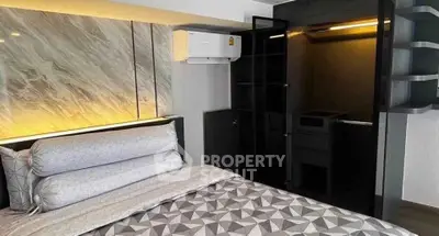 Modern bedroom with stylish decor and built-in closet, featuring elegant lighting and contemporary design.