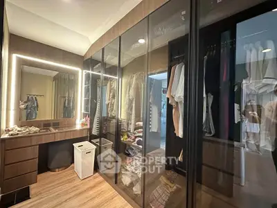 Luxurious walk-in closet with elegant lighting and ample storage space.