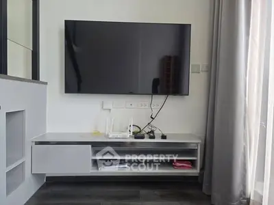 Modern living room with wall-mounted TV and sleek storage unit