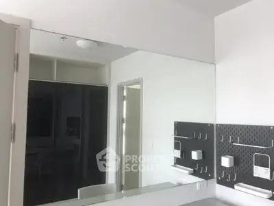Modern bathroom with sleek mirror and minimalist design in contemporary apartment.