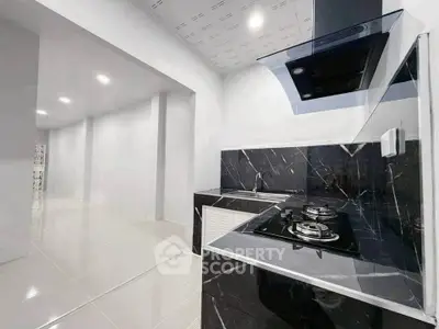Modern kitchen with sleek black marble countertops and gas stove