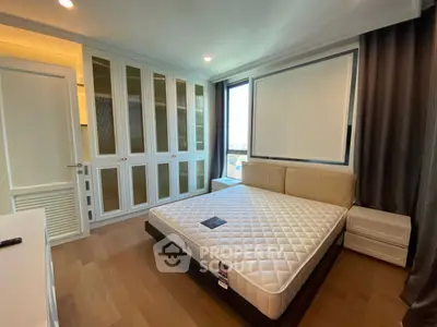 Spacious bedroom with large window and ample closet space in modern apartment.