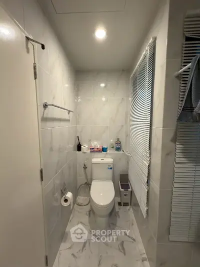 Modern bathroom with sleek marble tiles and compact design