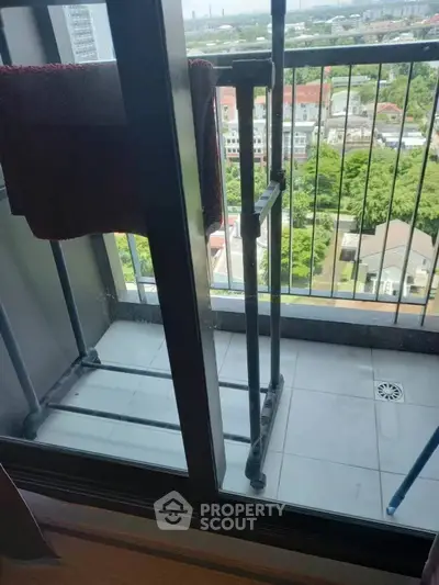 High-rise balcony with city view and drying rack, perfect for urban living.