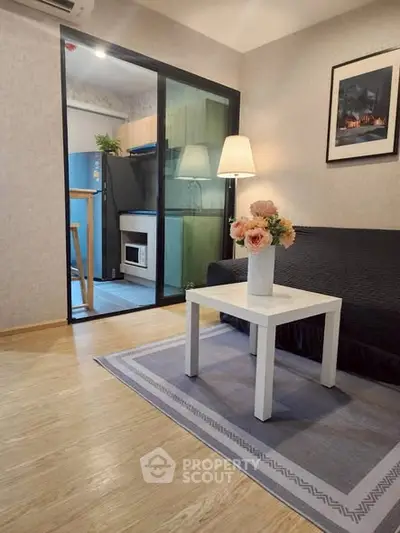 Charming living room with cozy decor and open kitchen layout, perfect for modern living.