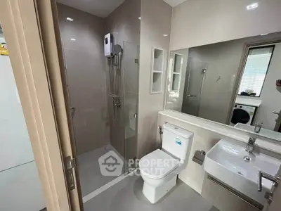 Modern bathroom with glass shower and sleek fixtures in contemporary apartment.