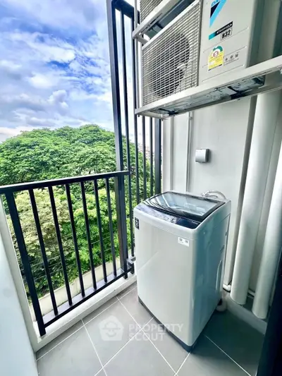Compact balcony with washing machine and lush green view