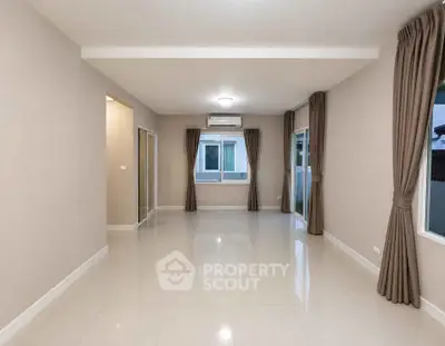 Spacious empty living room with large windows and elegant curtains, perfect for customization.