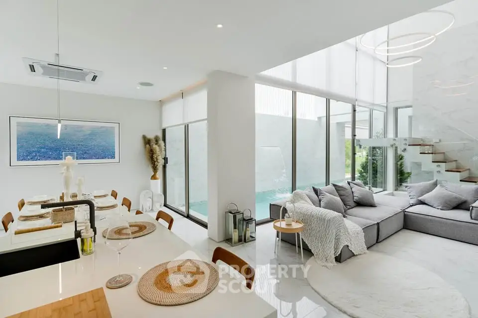 Luxurious open-plan living room with modern decor and pool view
